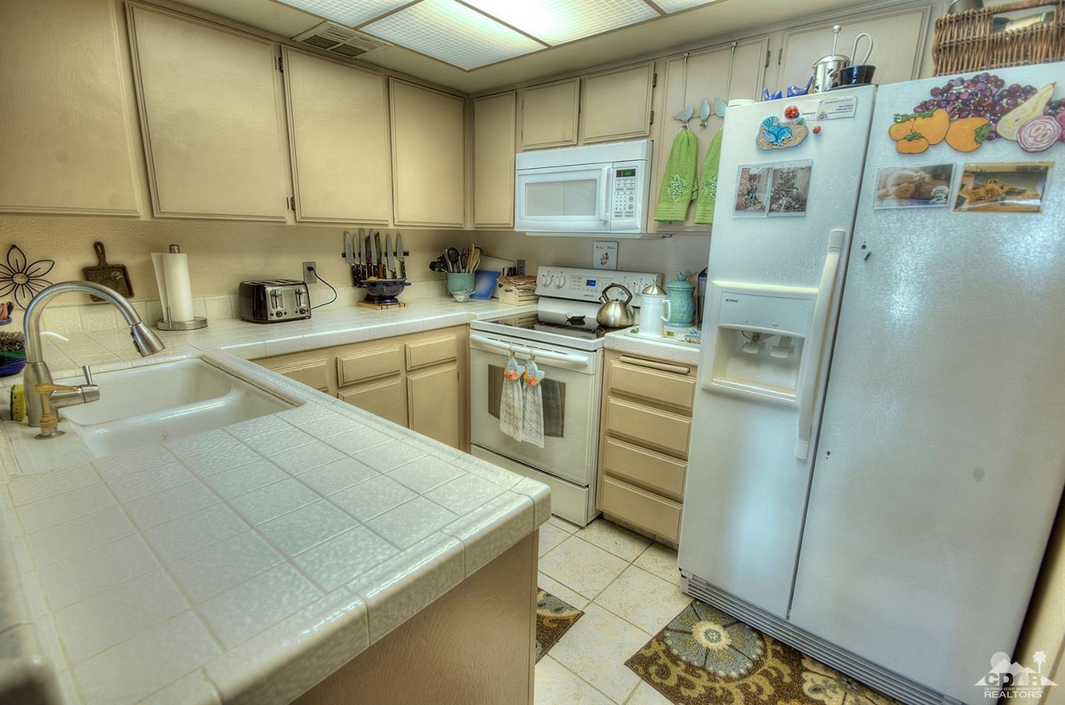 47395 Monroe Street, Unit 191 Indio, CA 92201 - Photo 6 of 21 a kitchen with a sink a stove and cabinets