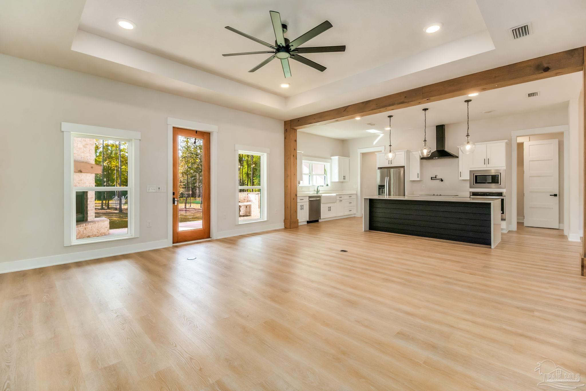 2329 Molino Bridge Road Pace, FL 32571 - Photo 14 of 65 a view of an empty room with a kitchen and chandelier fan