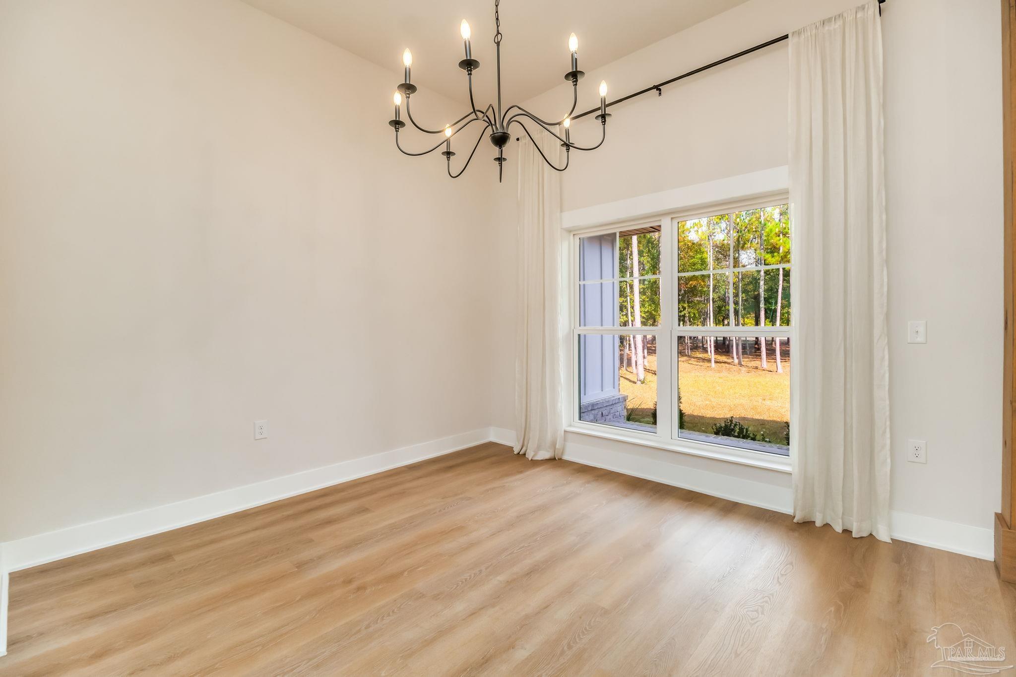 2329 Molino Bridge Road Pace, FL 32571 - Photo 24 of 65 a view of an empty room with wooden floor and a window