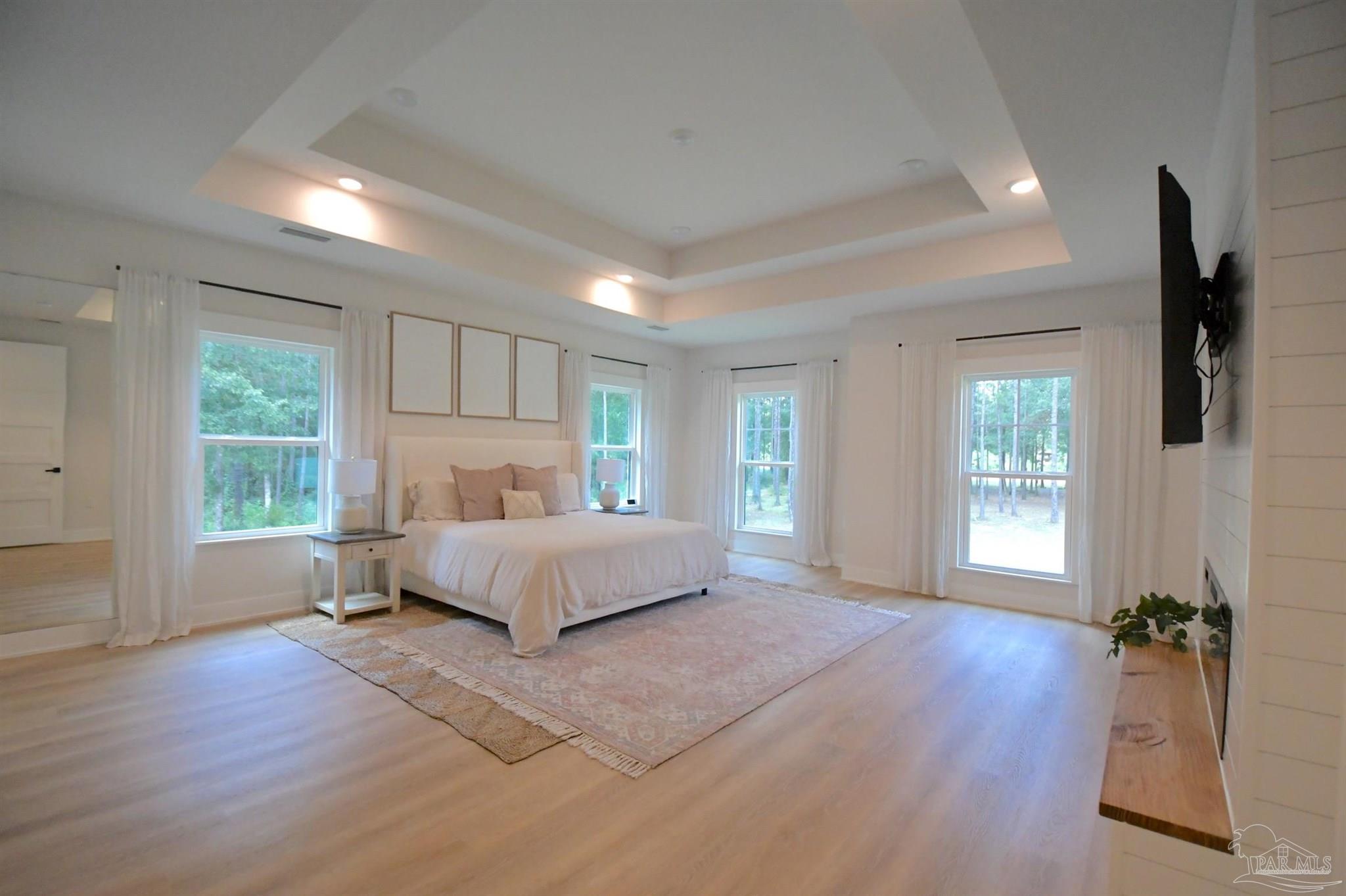 2329 Molino Bridge Road Pace, FL 32571 - Photo 27 of 65 a spacious bedroom with a large bed and a wooden floor