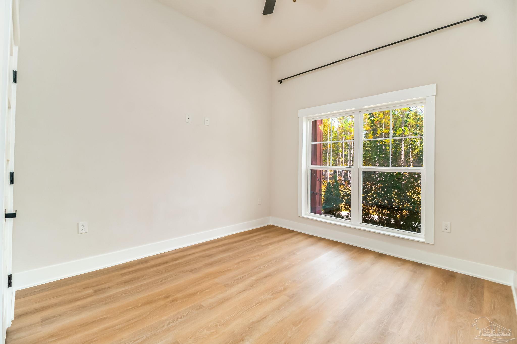 2329 Molino Bridge Road Pace, FL 32571 - Photo 39 of 65 an empty room with wooden floor and windows