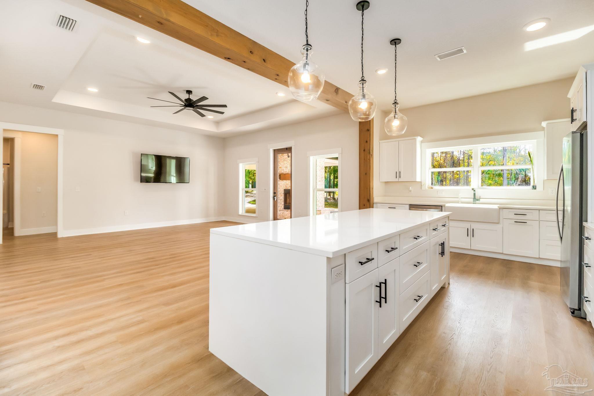 2329 Molino Bridge Road Pace, FL 32571 - Photo 10 of 65 a large kitchen with kitchen island a stove a sink a center island and wooden floor