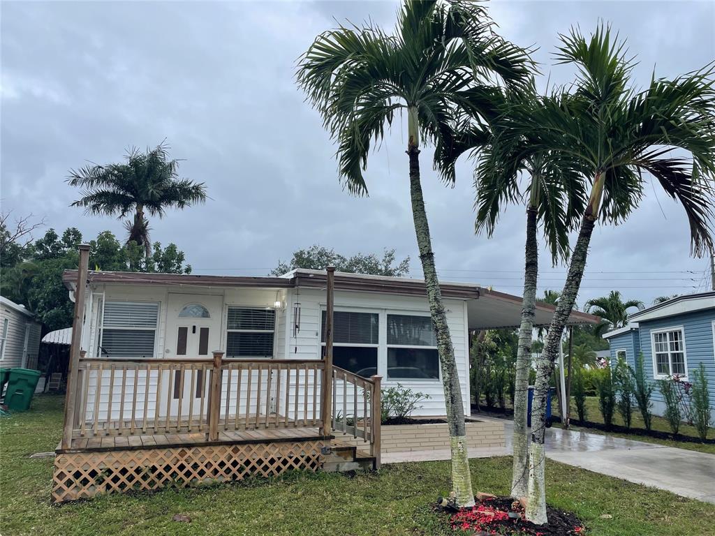 a view of a house with a yard and potted plants