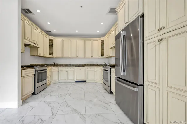 a kitchen with white cabinets and stainless steel appliances