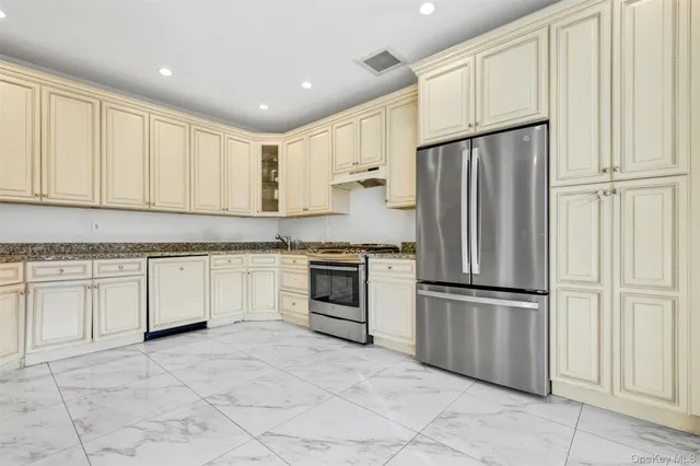 a kitchen with granite countertop white cabinets and stainless steel appliances