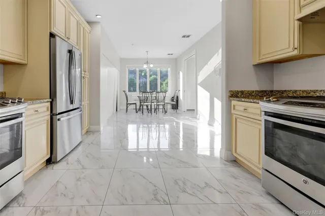 a kitchen with stainless steel appliances granite countertop a stove a refrigerator and a microwave