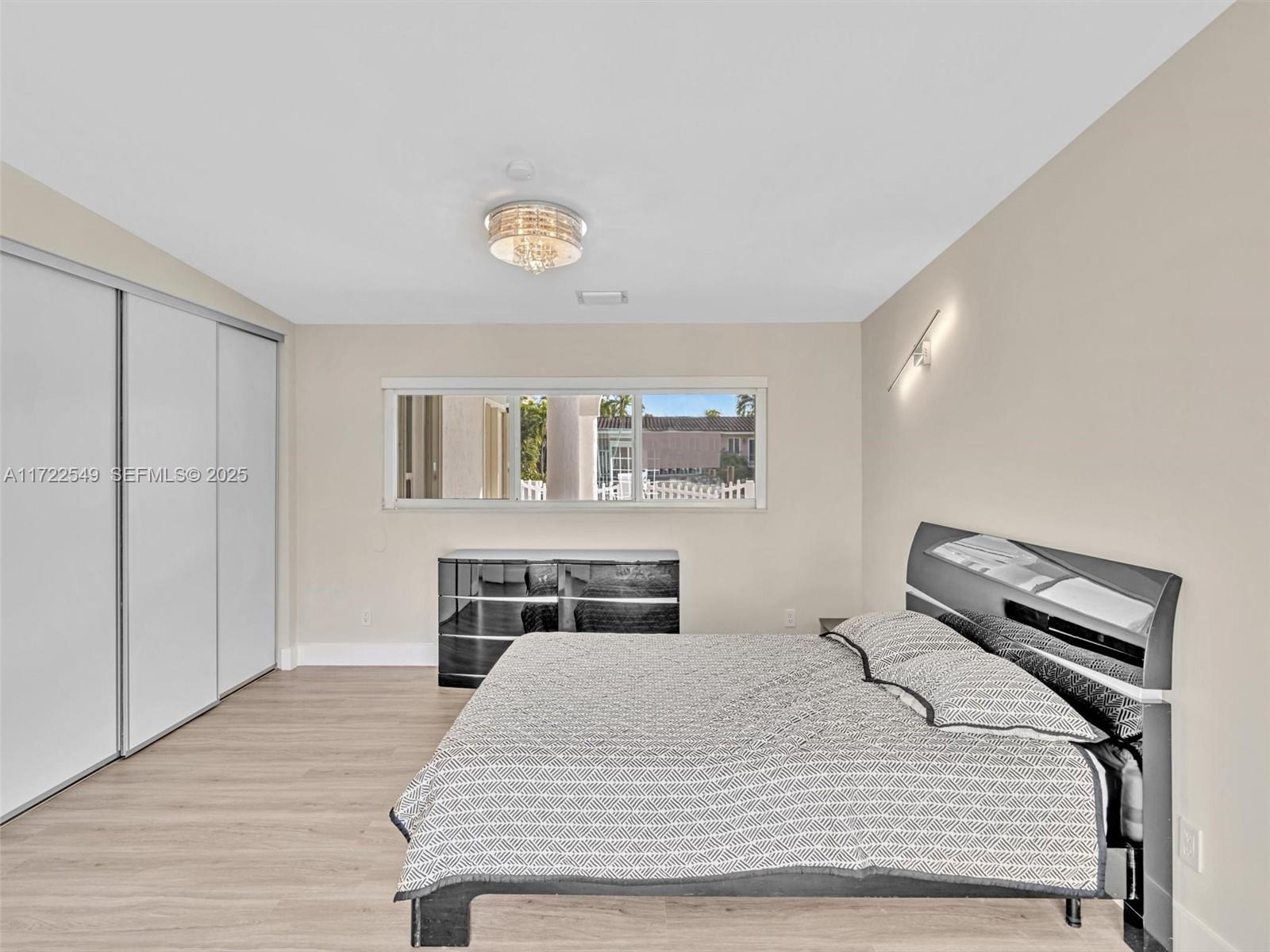 12904 Banyan Road North Miami, FL 33181 - Photo 55 of 87 a bedroom with a bed and a chandelier