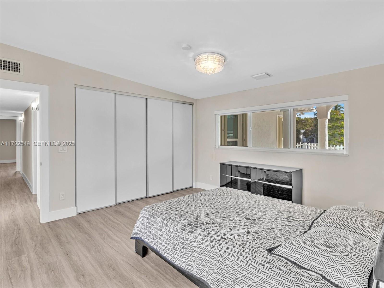 12904 Banyan Road North Miami, FL 33181 - Photo 57 of 87 a bedroom with a large bed and wooden floor