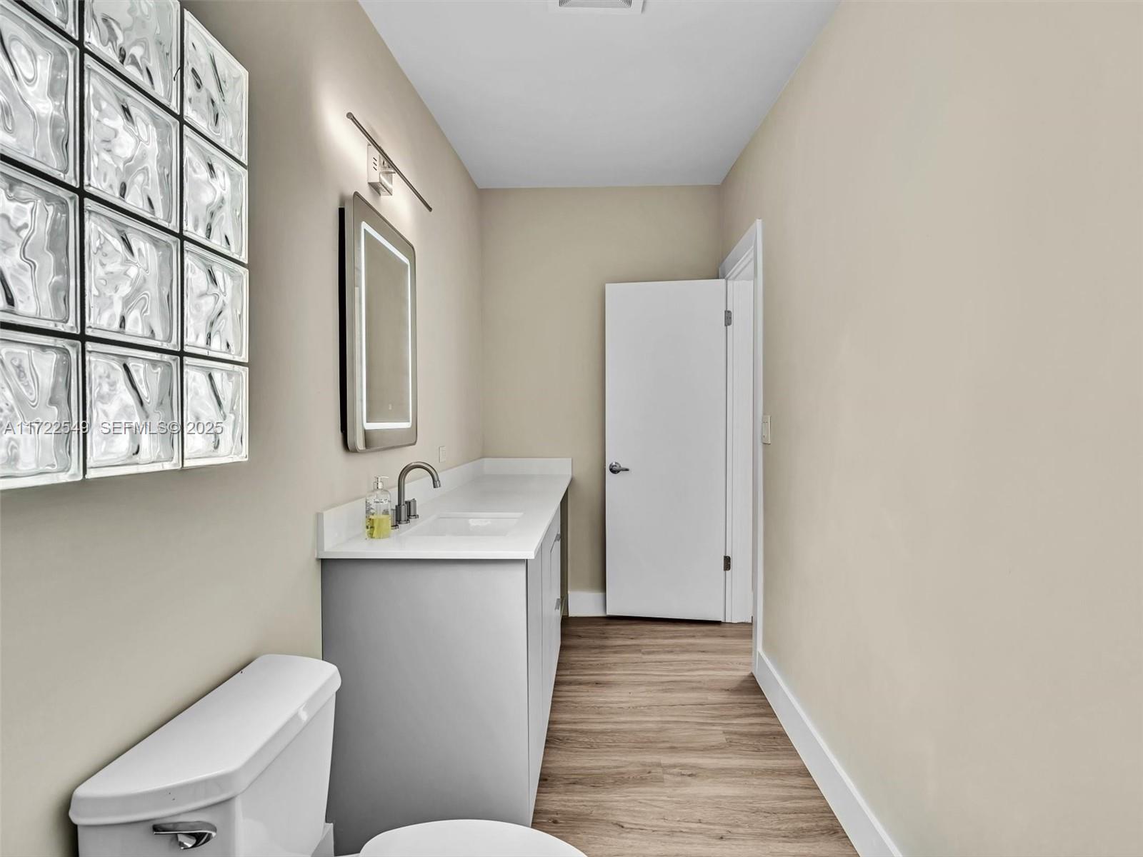 12904 Banyan Road North Miami, FL 33181 - Photo 60 of 87 a bathroom with a sink mirror toilet and next to a window
