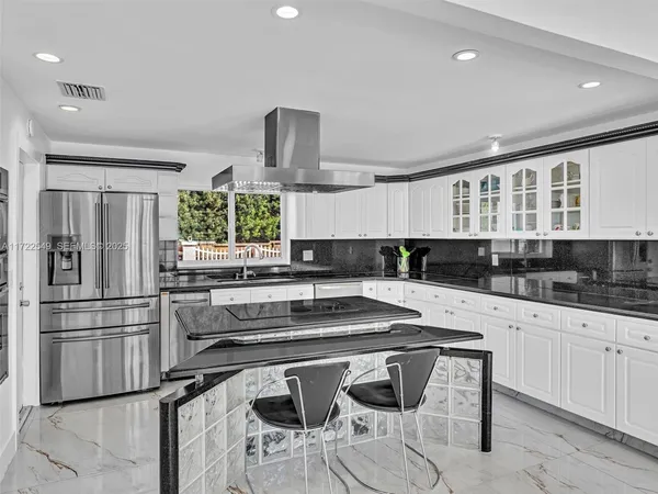 a kitchen with stainless steel appliances kitchen island granite countertop a sink and cabinets