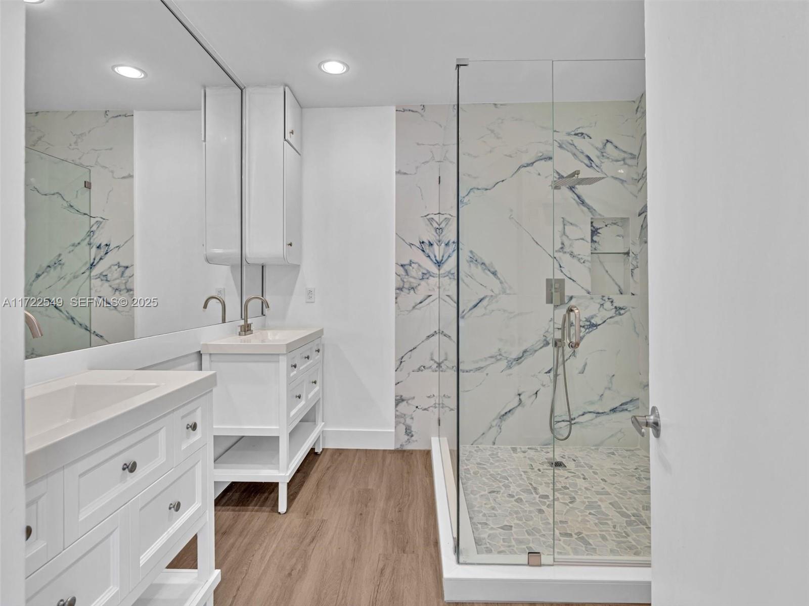 12904 Banyan Road North Miami, FL 33181 - Photo 70 of 87 a bathroom with a double vanity sink a mirror a shower and a bathtub