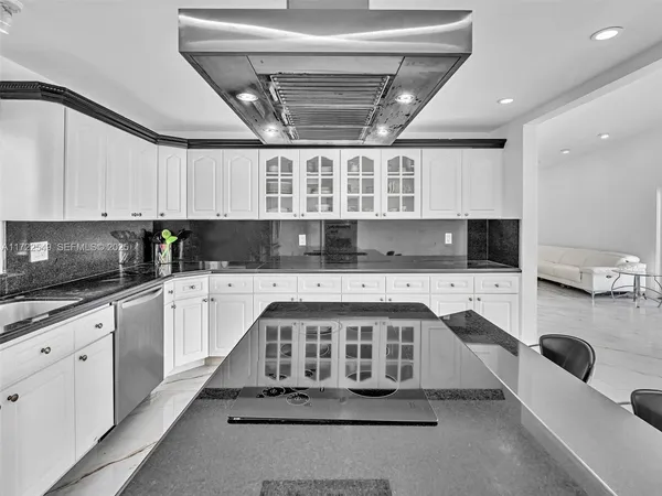 a kitchen with stainless steel appliances granite countertop a stove a sink dishwasher and white countertops with cabinets