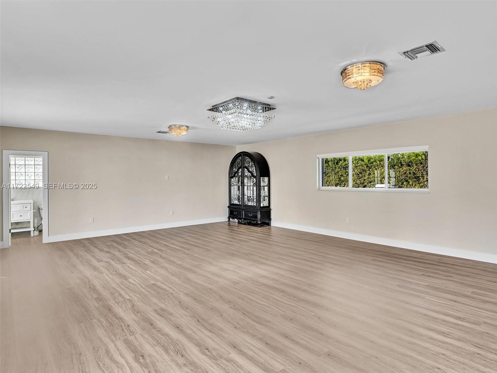 12904 Banyan Road North Miami, FL 33181 - Photo 75 of 87 a view of an empty room with a window and wooden floor