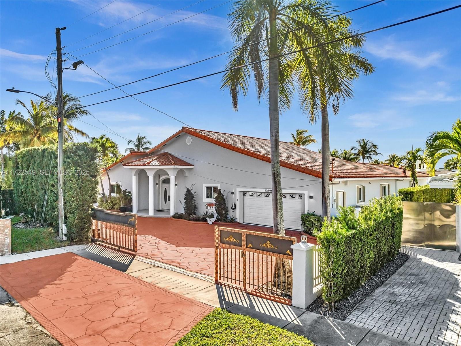 12904 Banyan Road North Miami, FL 33181 - Photo 83 of 87 a front view of a house with a yard and potted plants