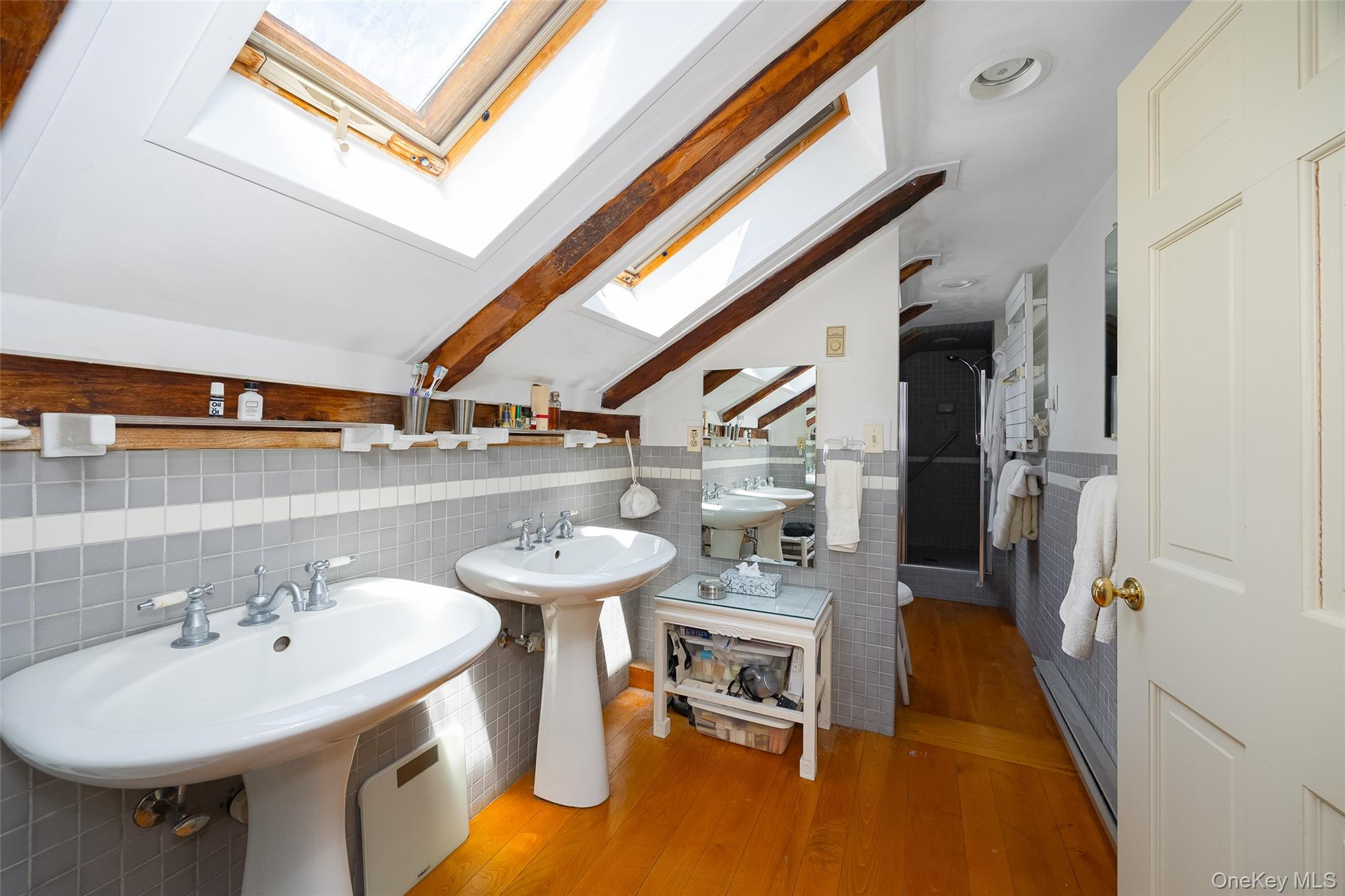 212 Pleasant Ridge Road Poughquag, NY 12570 - Photo 28 of 43 Upstairs bathroom featuring dual pedestal sinks, wood flooring, and exposed hand-hewn beams