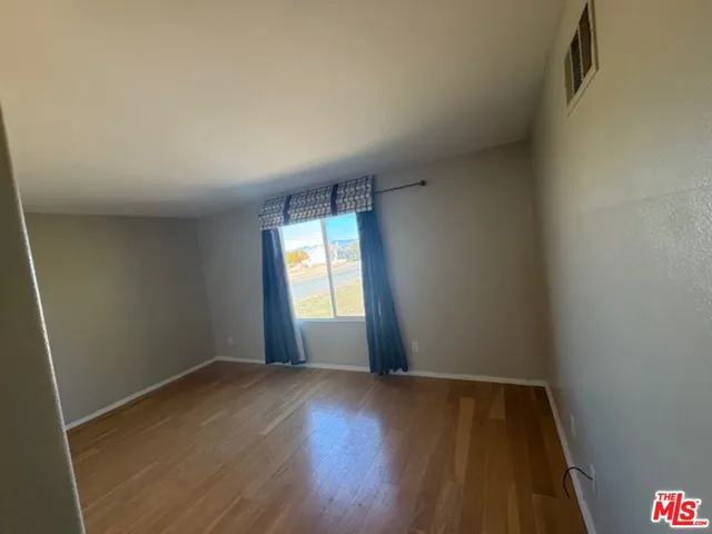 an empty room with cabinet and mirrors