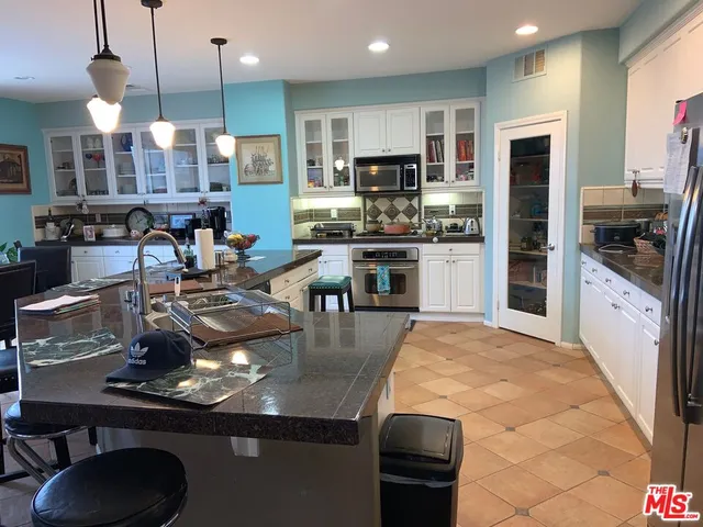 a kitchen with stainless steel appliances granite countertop a sink a stove and a refrigerator