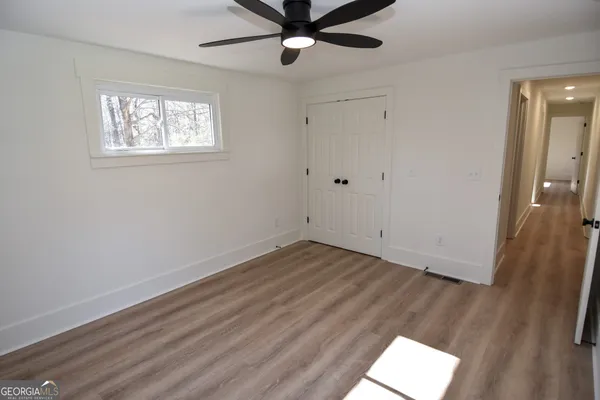 an empty room with wooden floor and windows