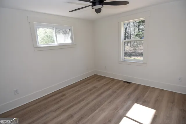 a view of a room with wooden floor and white walls