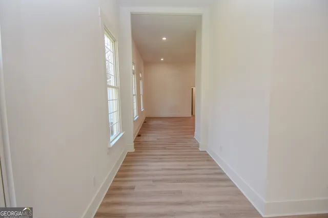 a view of a hallway with wooden floor and staircase