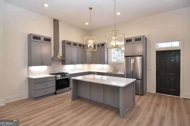 a kitchen with kitchen island a counter top space cabinets and stainless steel appliances