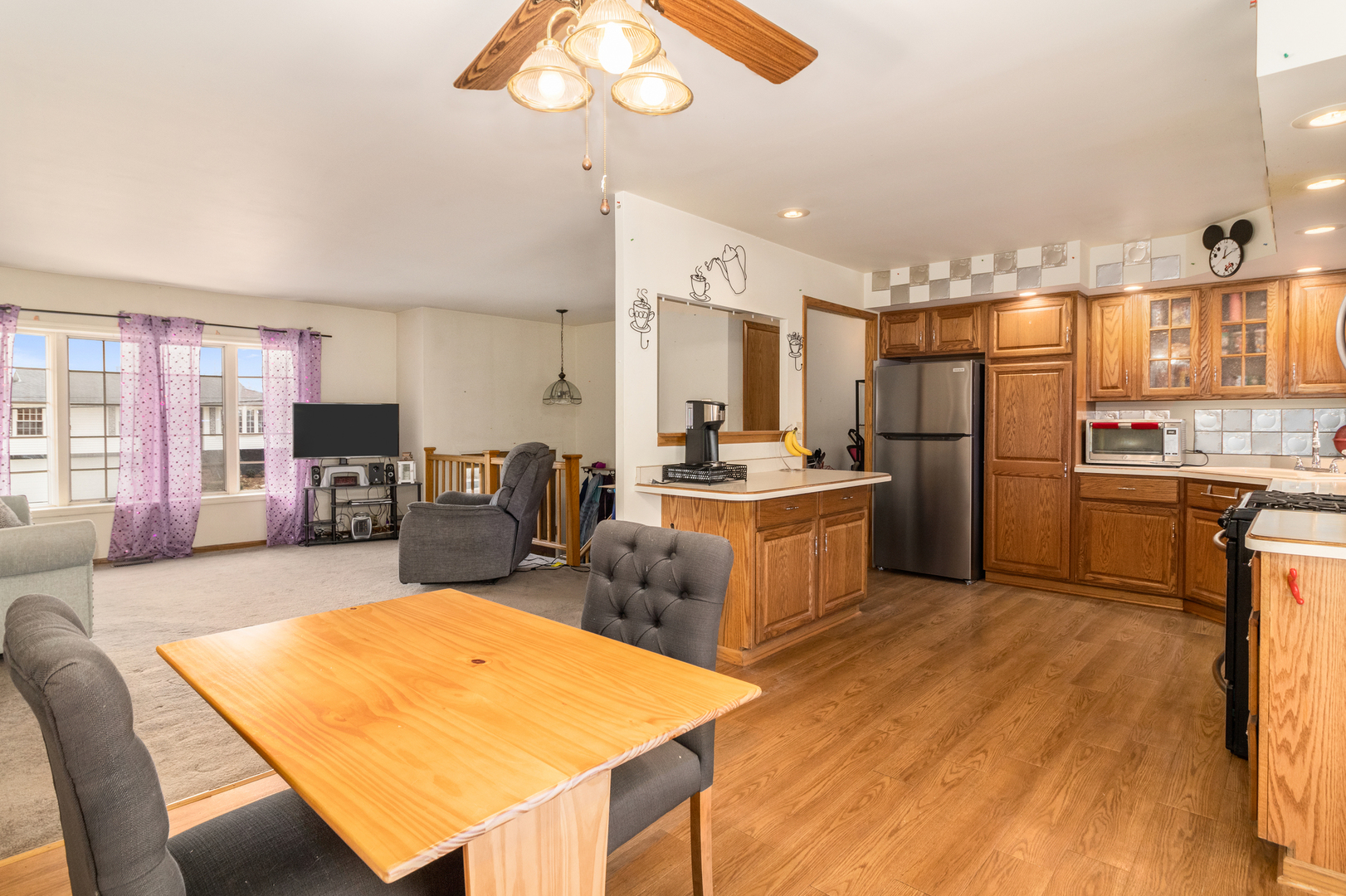 620 West Romeo Road Romeoville, IL 60446 - Photo 3 of 16 a living room with stainless steel appliances kitchen island a table chairs and a refrigerator