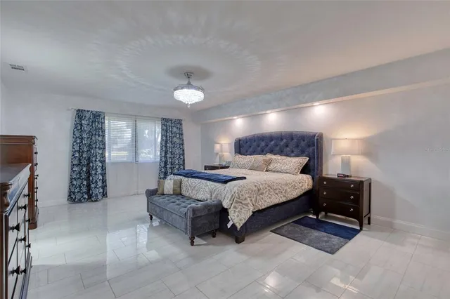 a bedroom with a large bed and a flat tv screen on a dresser