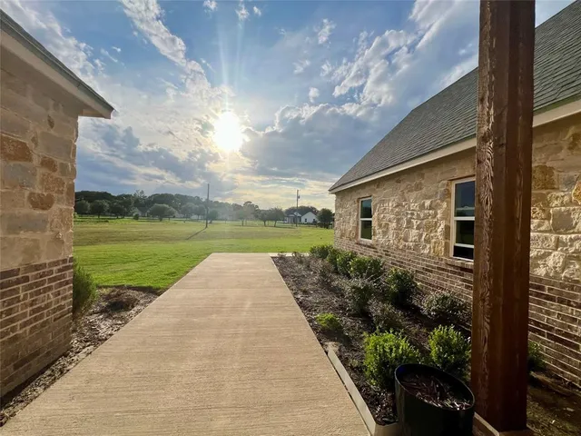 a view of a porch with a big yard potted plants and a large window