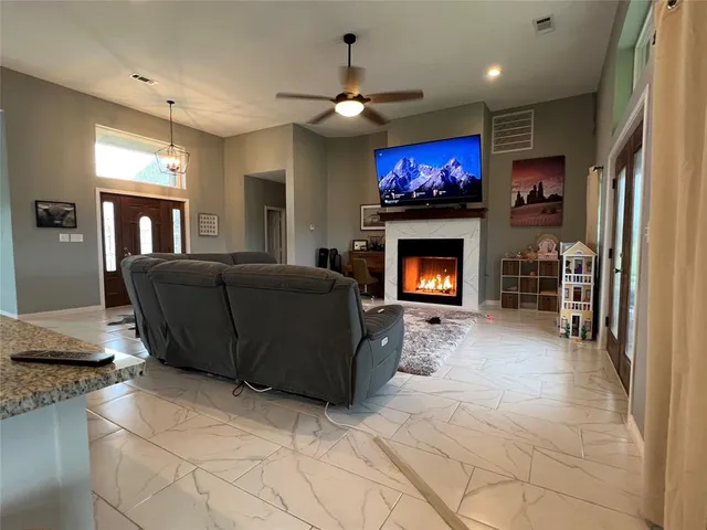 a living room with furniture a fireplace and a flat screen tv
