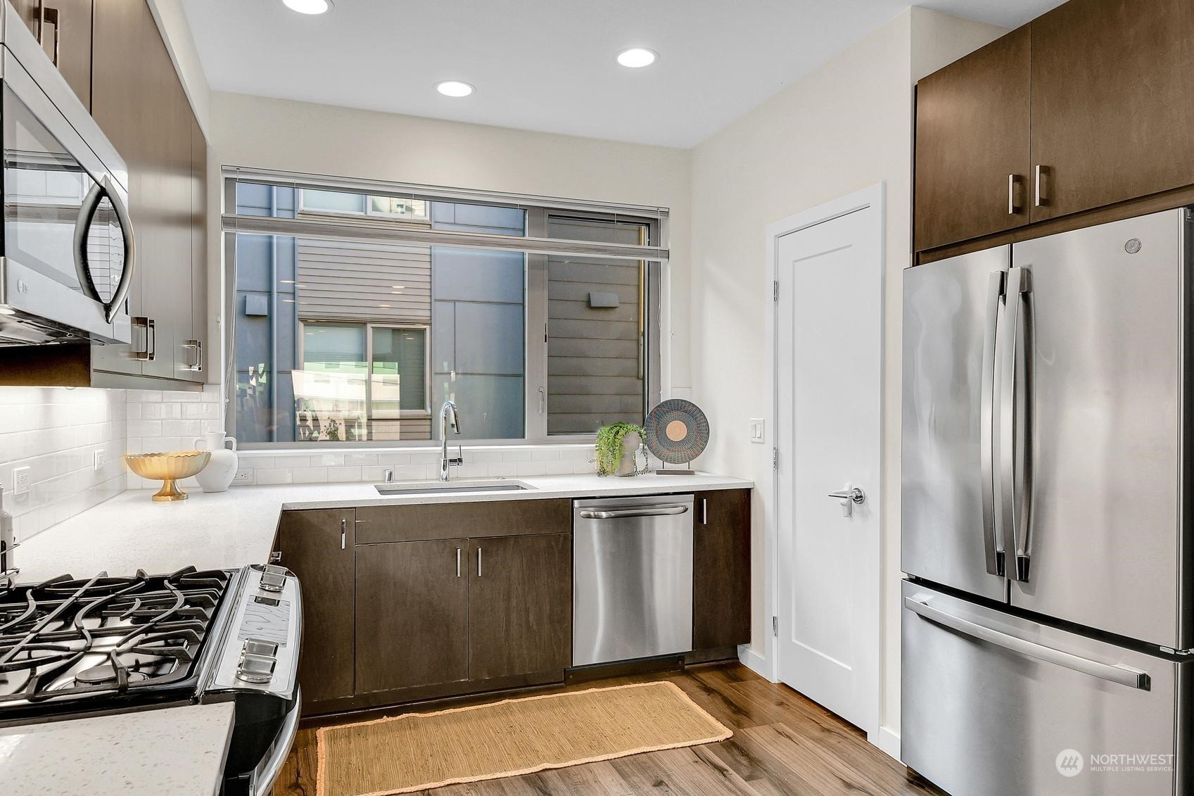 1907 25th Avenue South, Unit A Seattle, WA 98144 - Photo 6 of 23 a kitchen with stainless steel appliances granite countertop a sink and a refrigerator