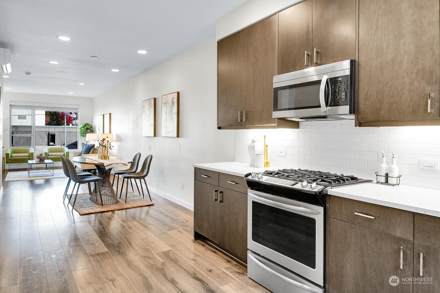 1907 25th Avenue South, Unit A Seattle, WA 98144 - Photo 9 of 23 a kitchen with stainless steel appliances a stove a sink cabinets and a wooden floor