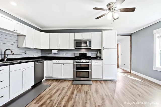 a kitchen with granite countertop a stove a sink and a microwave