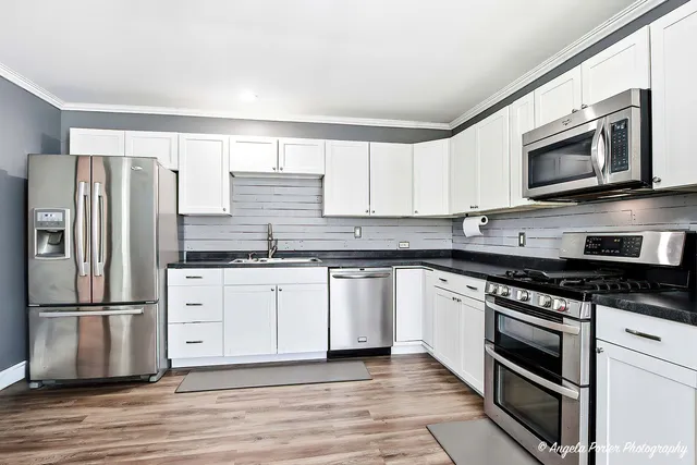 a kitchen with granite countertop a refrigerator stove and microwave