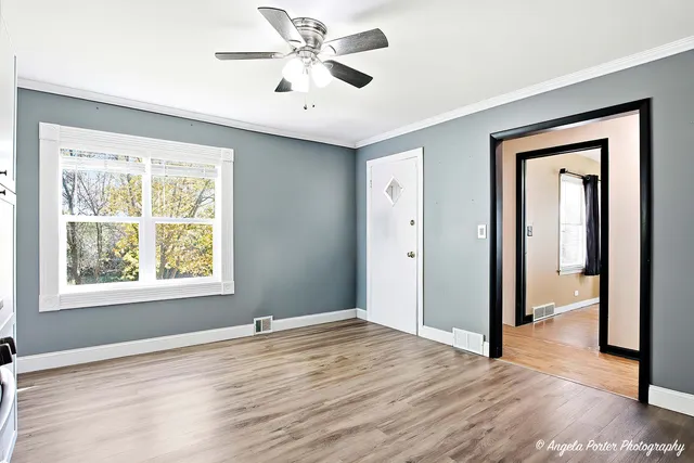 a view of an empty room window and wooden floor
