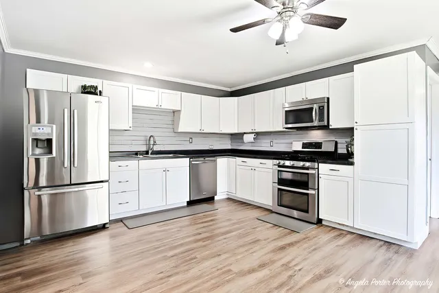 a kitchen with granite countertop a refrigerator stove and microwave