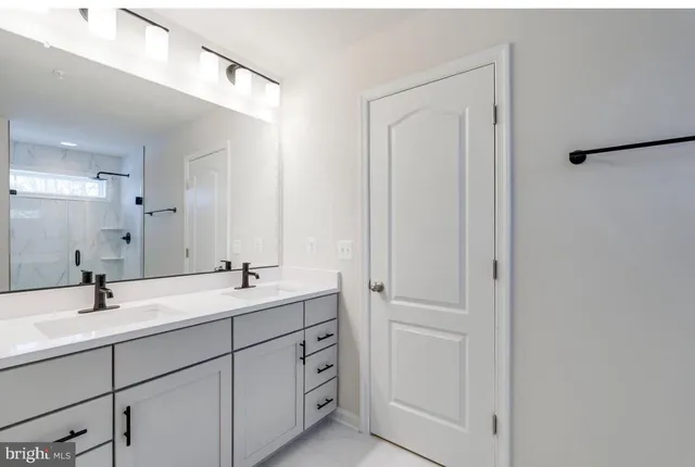 a bathroom with a double vanity sink and mirror