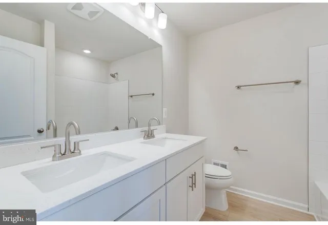 a bathroom with a sink a toilet and a mirror