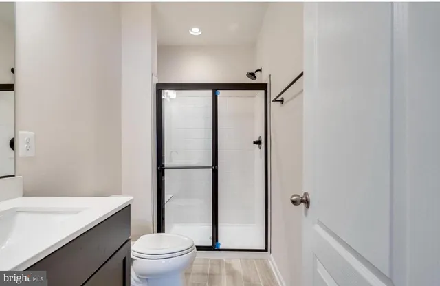 a bathroom with a granite countertop sink toilet and shower