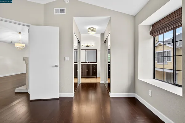 a view of a hallway with wooden floor and a cabinet