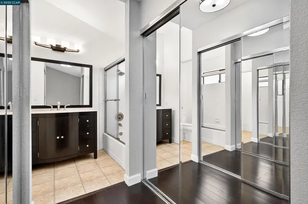 a view of a hallway with windows and chandelier