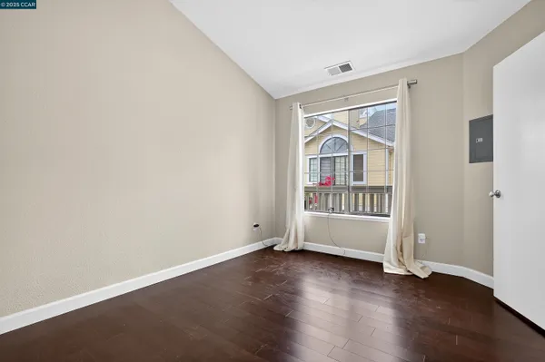 an empty room with wooden floor and a window
