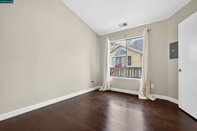 an empty room with wooden floor and a window