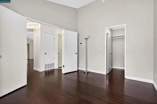 an empty room with wooden floor and closet