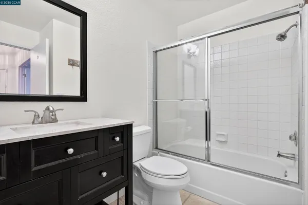 a bathroom with a sink a mirror a toilet and shower