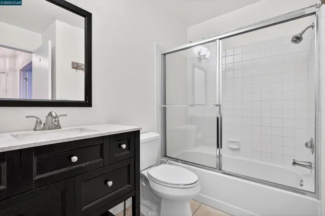 a bathroom with a sink a mirror a toilet and shower