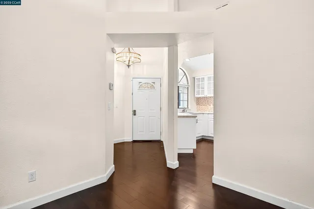 an empty room with wooden floor and mirror