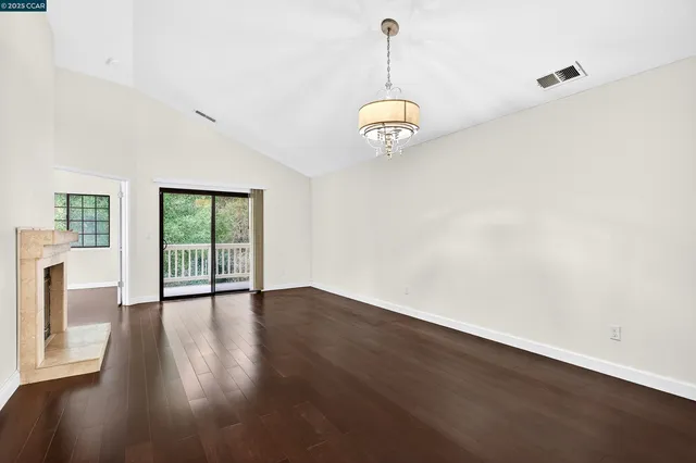 a view of empty room with wooden floor and window