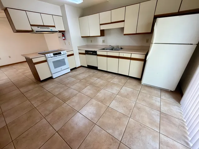 a kitchen with stainless steel appliances granite countertop a sink a stove a refrigerator a microwave and cabinets