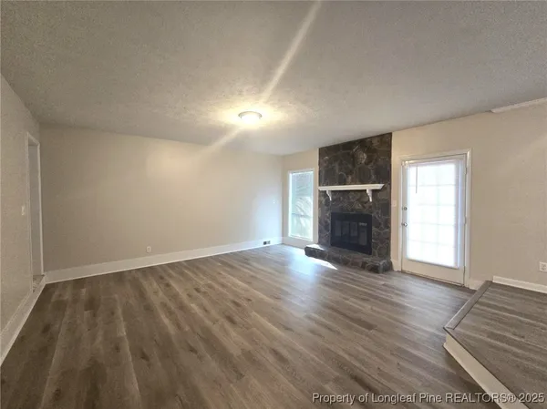 an empty room with wooden floor and fireplace
