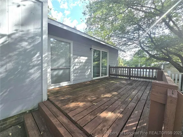 a view of backyard with wooden floor and fence